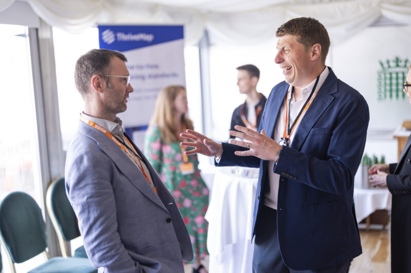 People chatting at professional networking event indoors.