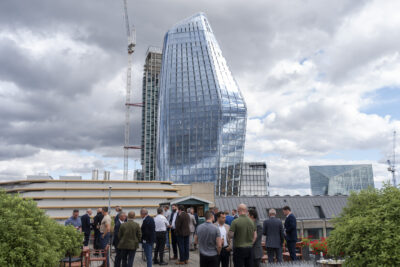 People on rooftop with modern glass buildings.