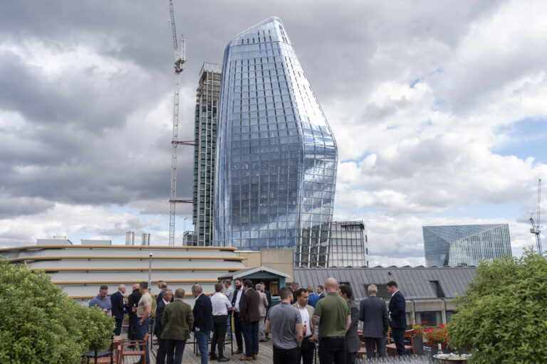 People on rooftop with modern glass buildings.