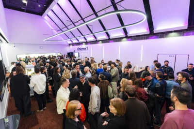 Crowded cinema foyer with people socialising.