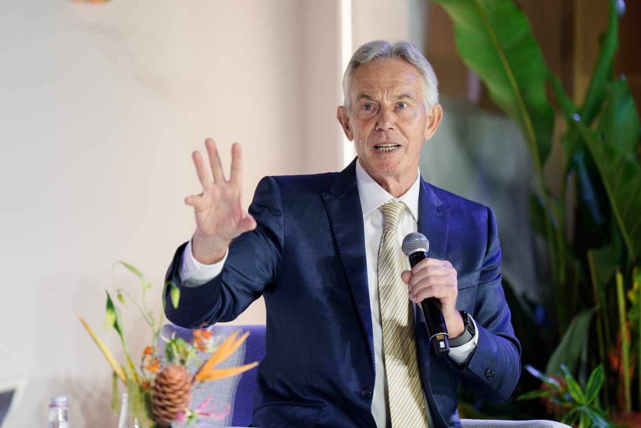 Man in suit speaking into microphone at event
